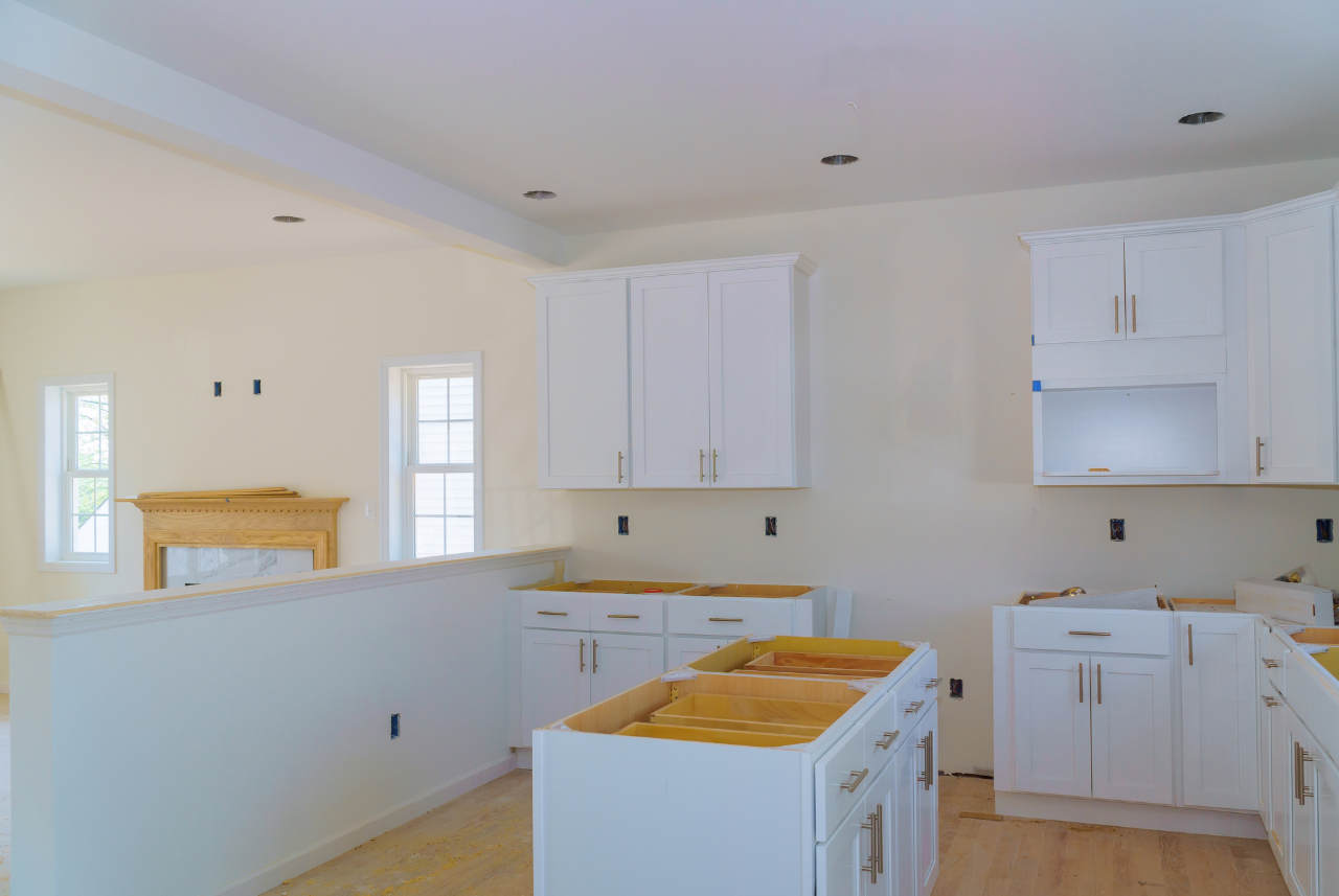 Custom cabinets Milwaukee – Spacious kitchen undergoing renovation with white cabinets and a marble fireplace surround. Custom cabinets Milwaukee - Spacious kitchen undergoing renovation with white cabinets and a marble fireplace surround.