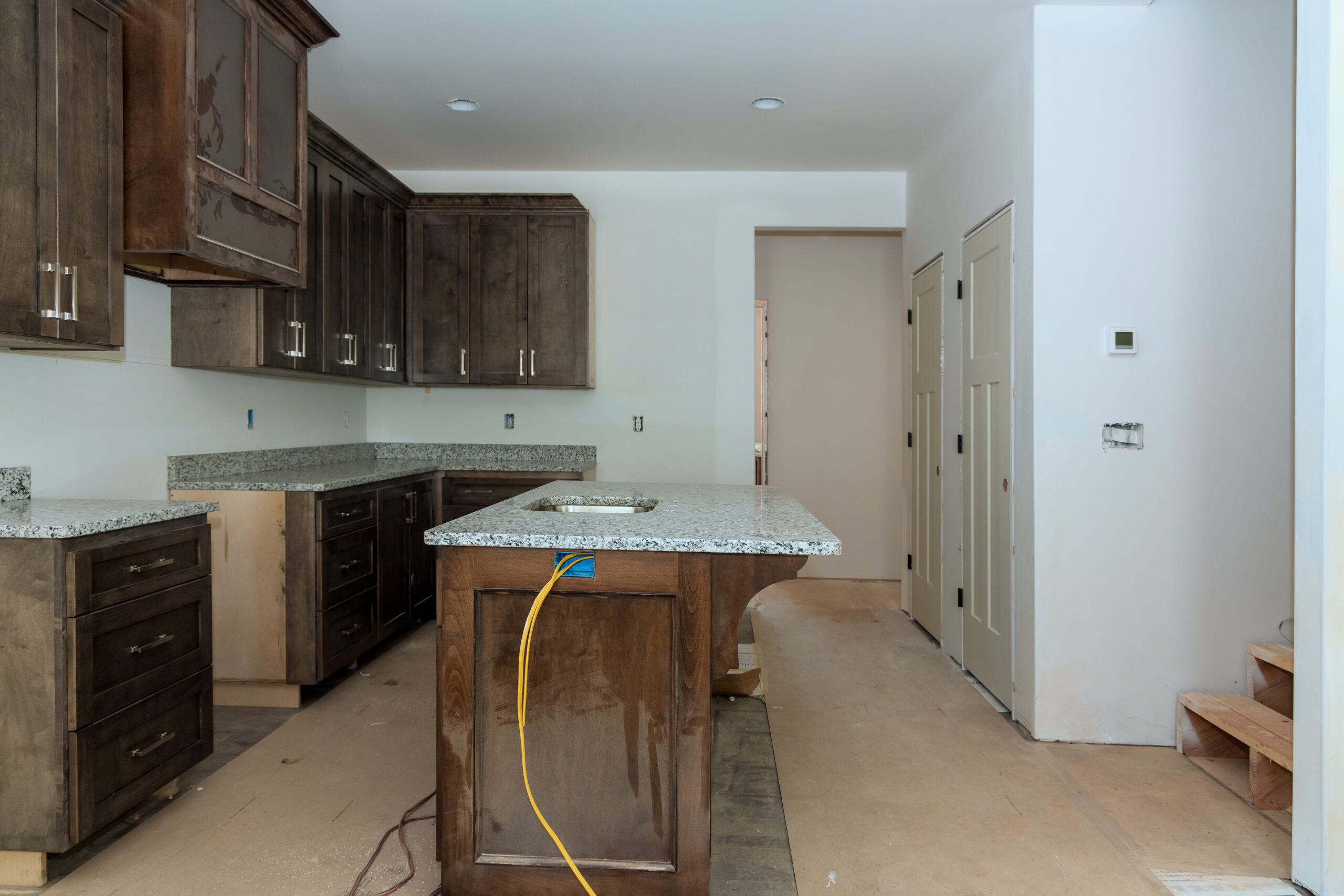 Under construction is new home with custom modular kitchen consisting of cabinets an island in a center Under construction is new home with custom modular kitchen consisting of cabinets an island in center